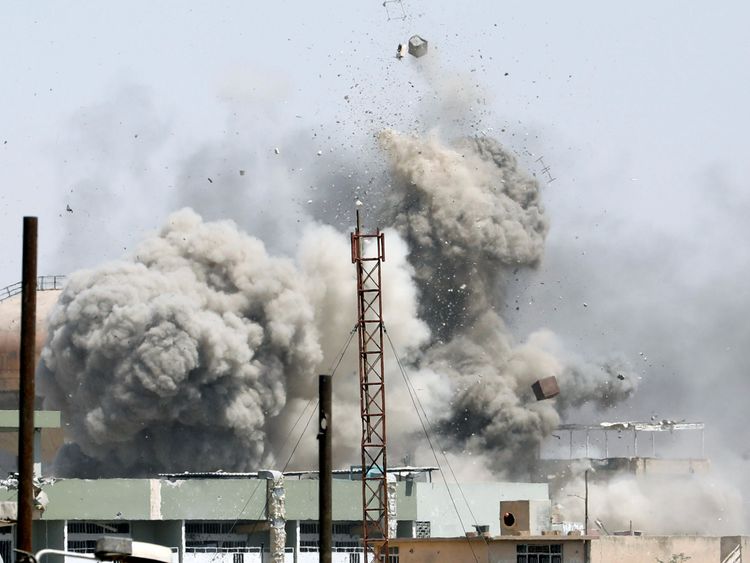 Debris fly as smoke rises after an artillery attack on the Islamic State militants' positions