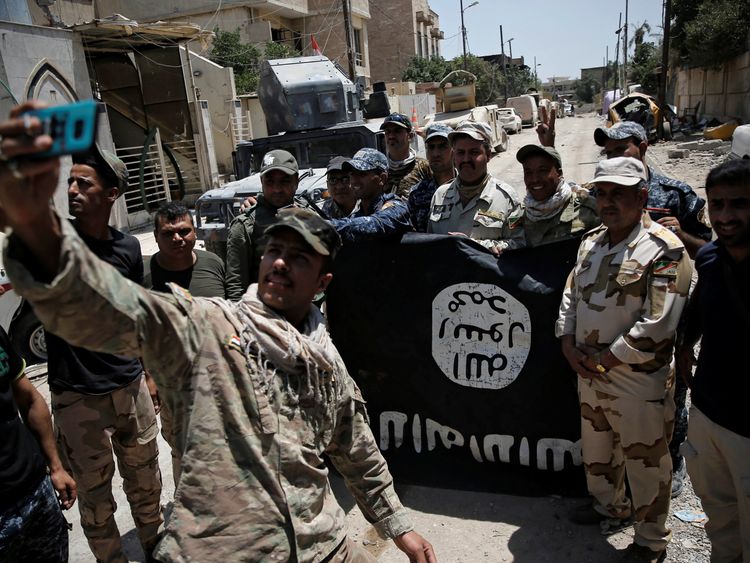 Iraqi troops with a captured Islamic State flag