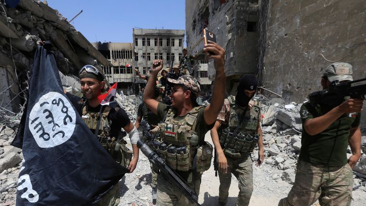 Iraqi forces celebrate with a captured IS flag