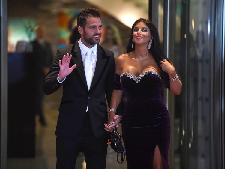 Chelsea&#39;s football player Cesc Fabregas and his wife pose on a red carpet upon arrival to attend Argentine football star Lionel Messi and Antonella Roccuzzo&#39;s wedding