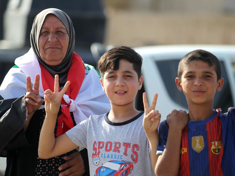 Iraqi civilians flash the sign for victory as they celebrate in the Old City of Mosul on July 9, 2017 after the government's announcement of the 'liberation' of the embattled city.