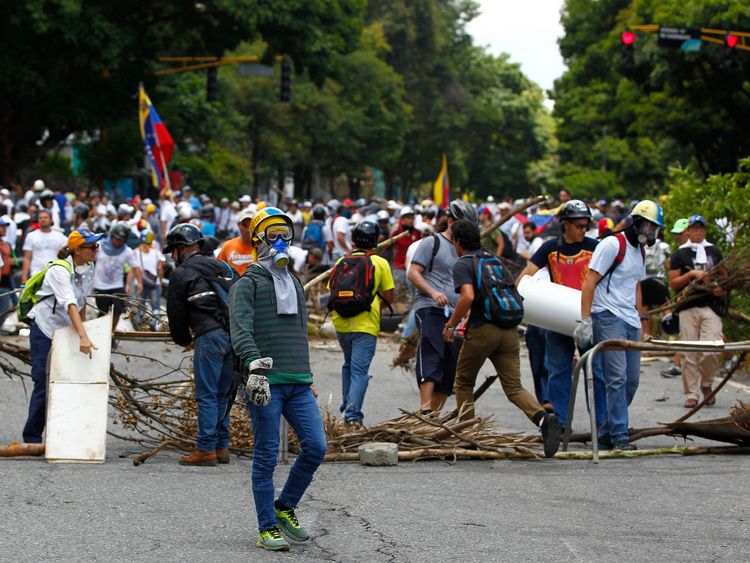Opposition supporters stand near a barricade in Caracas