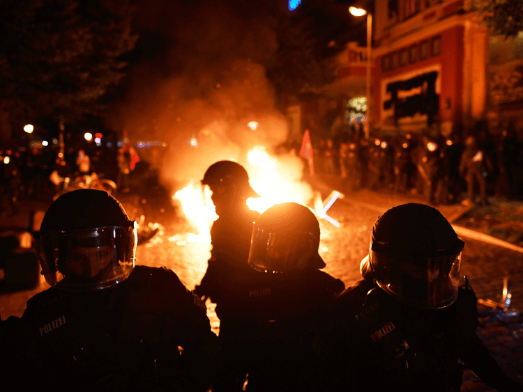 Riot police gather after protesters erected burning barricades in front of the Rote Flora left-wing centre after the 'Welcome to Hell' protest