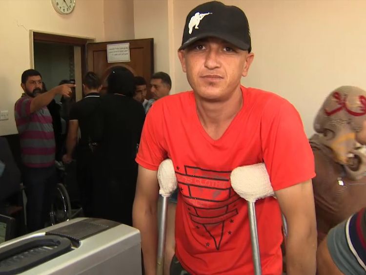 A man on crutches waits in line for treatment