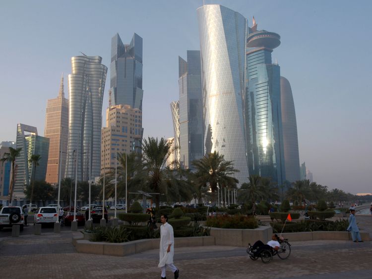 A man walks on the corniche in Doha, Qatar