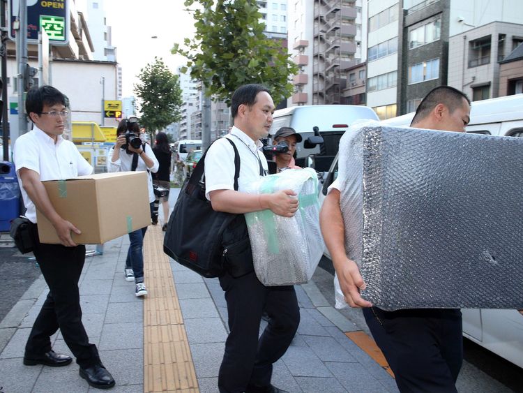 Police officers carry pieces of evidence out of house of Mark Karpeles, the head of defunct Bitcoin exchange MtGox, in Tokyo on August 3, 2015
