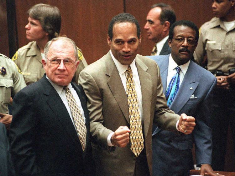 Murder defendant O.J. Simpson listens to the not guilty verdict with his attorneys F. Lee Bailey (L) and Johnnie Cochran Jr (R)