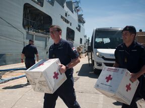 Members of the Royal Navy carry medical supplies on board the amphibious assault ship HMS Ocean at the Naval Base in Gibraltar on September 11, 2017, before leaving to provide humanitarian assistance and vital aid to British Overseas Territories and Commonwealth partners affected by Hurricane Irma.
