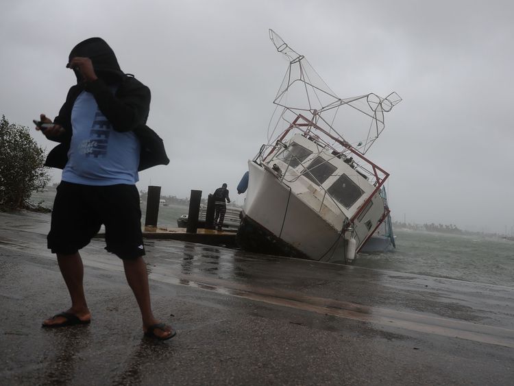 A boat is washed on shore at the Watson Island marina in Miami