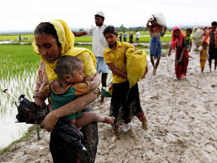 A Rohingya woman and her child travel to Bangladesh from Myanmar