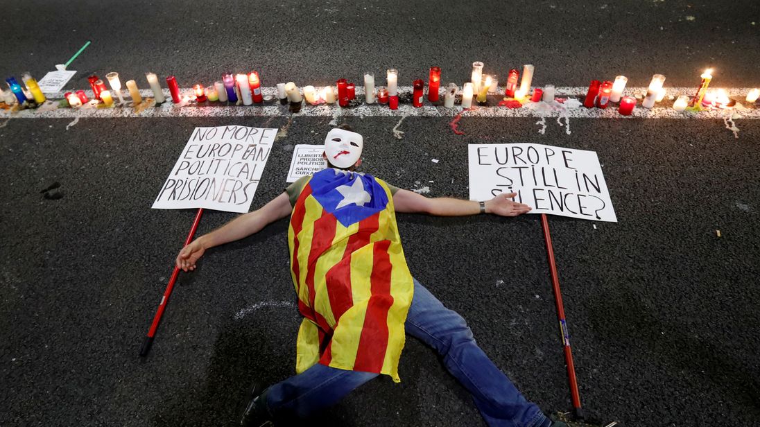 A man with a Catalan separatist flag lies on the ground during a protest in Barcelona