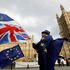 An anti-Brexit demonstrator waves a Union flag alongside a European Union flag outside the Houses of Parliament