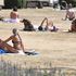 People sunbathe in Haggerston Park, in east London in July