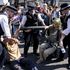 Police try to move climate activists who have glued their hands to a pipe in Oxford Circus