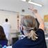 A Year 6 pupil wearing a face mask raises a hand to ask a question in a classroom at the College Francais Bilingue De Londres French-English bilingual school in north London on June 2, 2020 as schools in England partially reopen from coronavirus shutdown. - Schools partially reopened in England on June 2 and the most vulnerable were allowed to venture outdoors, despite warnings that the world