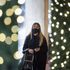 A woman wearing a face mask walks past Christmas lights outside a department store in central London. A new three-tier system of alert levels for England has been implemented following rising coronavirus cases and hospital admissions.