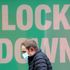 A man walks past a poster in the window of a Primark shop in Manchester, in the final week of a four week national lockdown to curb the spread of coronavirus.