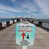 A social distancing sign on the pier in Llandudno, Wales