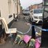 Flowers are left at the crime scene where a 31-year-old woman suffered severe burns and later died