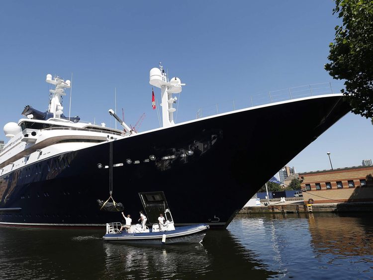 Crew works around Octopus, luxury yacht owned by Microsoft co-founder Paul Allen, moored at Canary Wharf, London