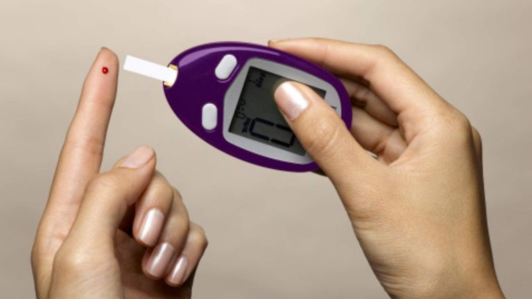 A woman using a diabetes test kit