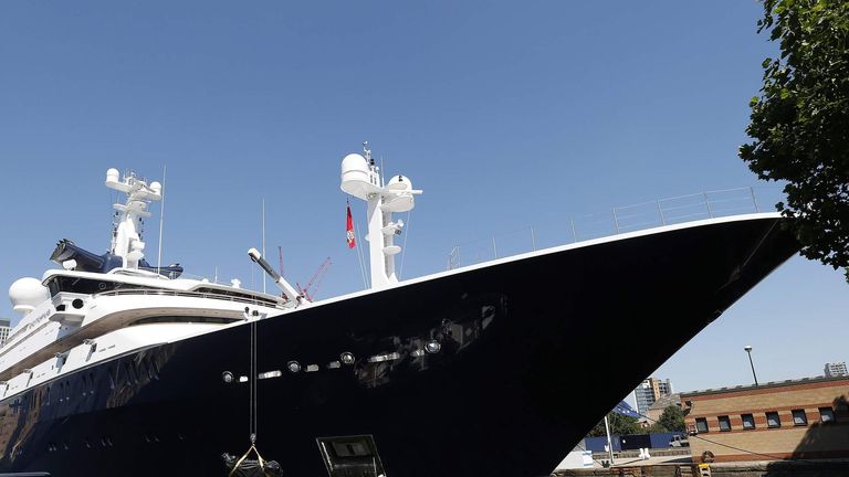 Crew works around Octopus, luxury yacht owned by Microsoft co-founder Paul Allen, moored at Canary Wharf, London