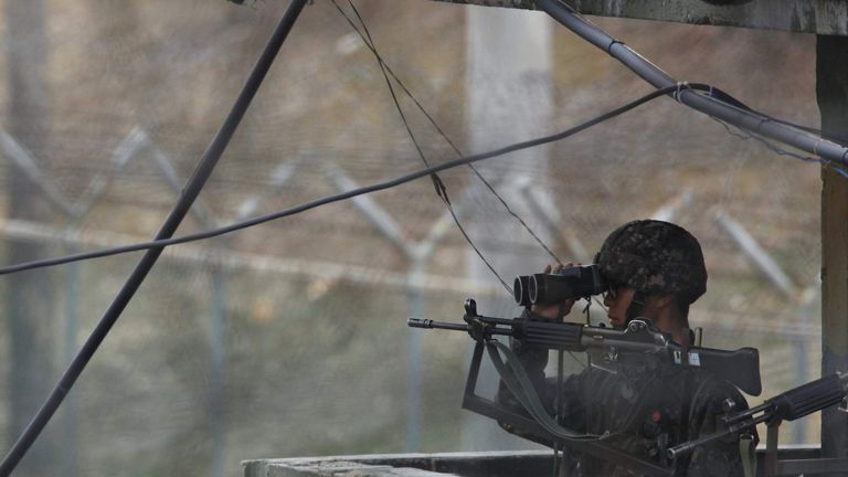 A South Korean soldier looks to the north through a pair of binoculars at an observation post near the DMZ in Paju