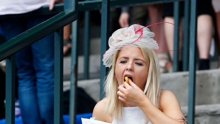 A woman enjoys some food during Scottish Grand National Day at Ayr