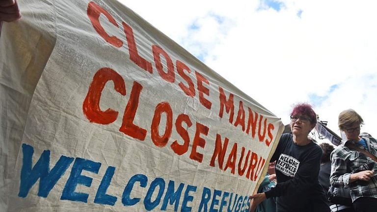 A pro-refugee protester holds up a banner outside the Transfield Services annual general meeting in Sydney last October