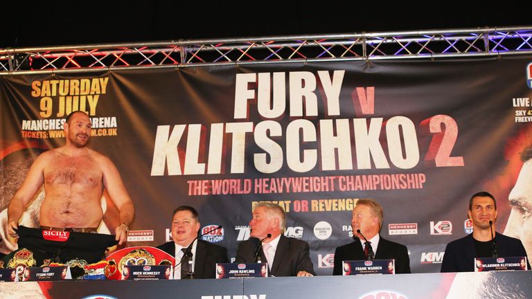 Tyson Fury (L) removed his shirt during the press conference