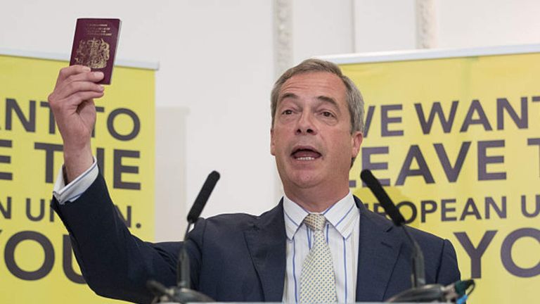 UKIP leader Nigel Farage holds up his British passport as he speaks at a Grassroots Out! campaign rally
