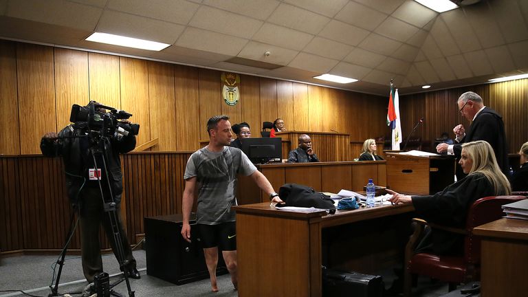 Paralympic athlete Oscar Pistorius walks in the courtroom without his prosthetic legs during resentencing hearing for the 2013 murder of Reeva Steenkamp