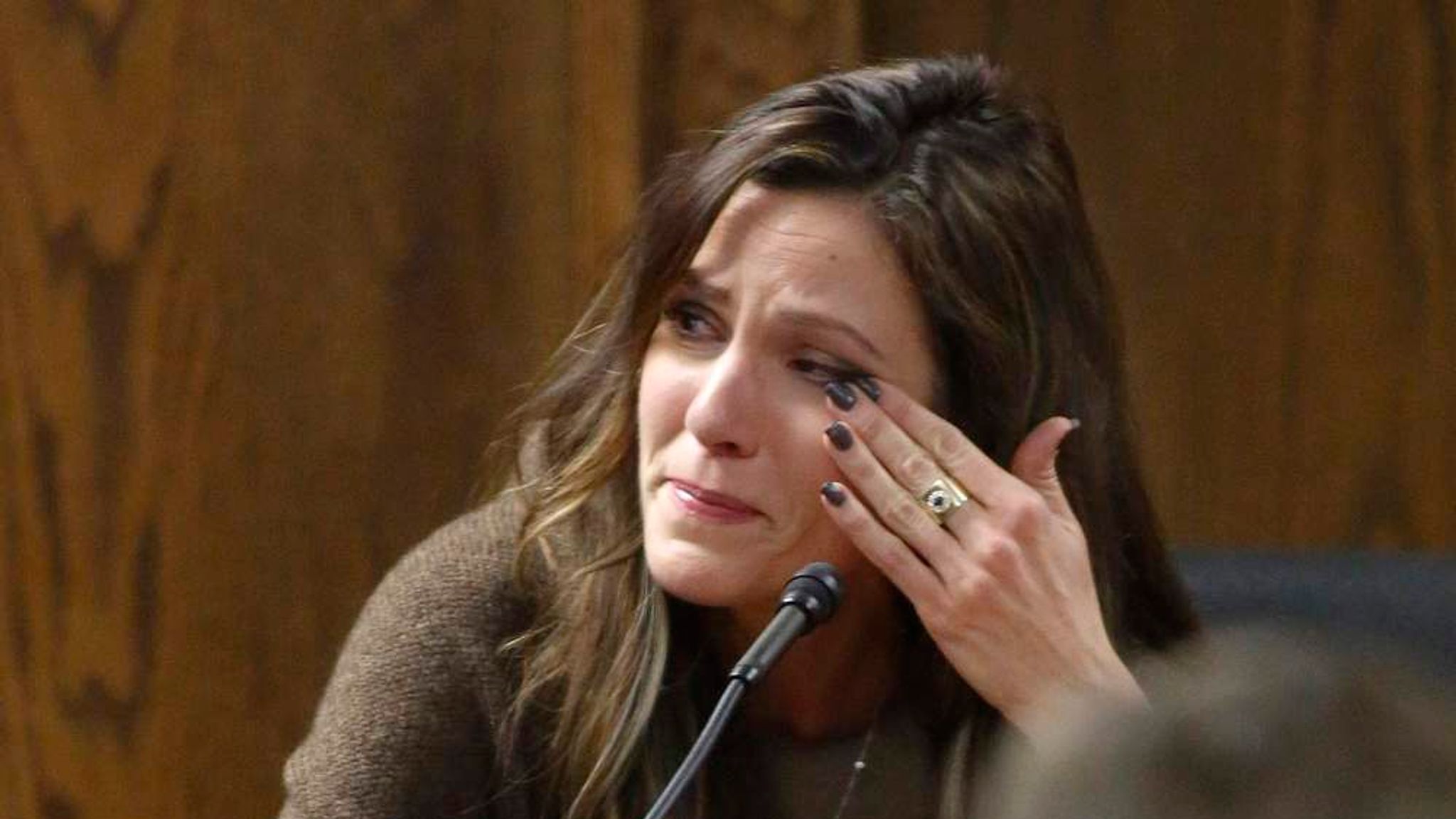 Chris Kyle's widow, Taya Kyle, wipes away tears as she testifies. 