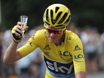Chris Froome holds a glass of champagne