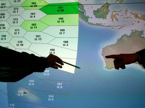 A person involved in the search points to a section of the screen showing a part of the southern Indian Ocean