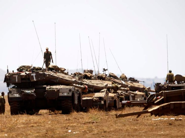 Israeli soldiers stand atop tanks before a drill near Kibbutz Ein Zivan close to the border crossing between Israel and Syria, in the Israeli-occupied Golan Heights