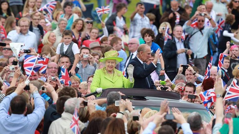 Britain&#39;s Queen Elizabeth II (Centre L) and Prince Phillip drive in a open top car as they attended a Diamond Jubilee event in the grounds of the Stormont Estate in Belfast, Northern Ireland, on June 27,