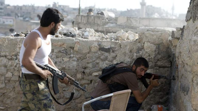Syrian rebels take cover during clashes in the old city of Aleppo, close to the souk or bazaar district