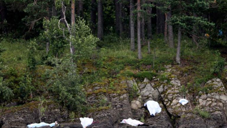 Covered corpses are seen on the shore of Utoya following shootings.