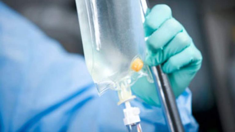 A generic picture of a medical person setting up or checking an IV drip