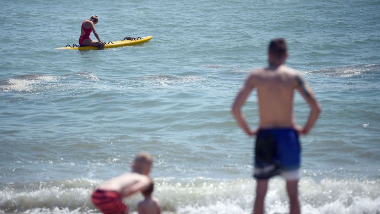 A lifeguard patrols on her surf board at the East beach in Bognor Regis, West Sussex