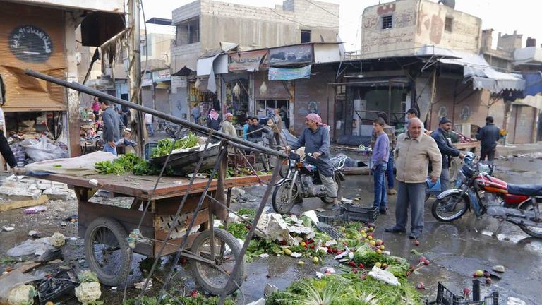 People inspect a site after hit by what activists said were air strikes by forces loyal to Syria's President Bashar al-Assad in Raqqa, eastern Syria, which is controlled by the Islamic State
