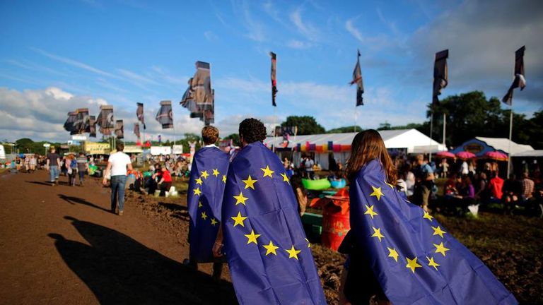 Revellers wrapped in European Union flags walk at Worthy Farm in Somerset during the Glastonbury Festival