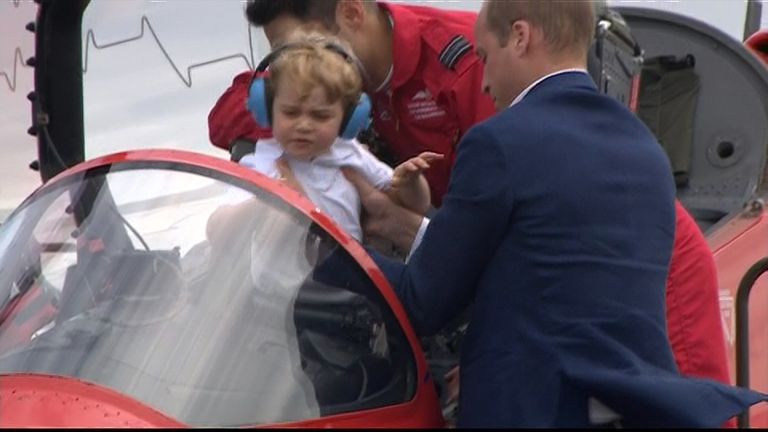 The Duke of Cambridge lifts his son Prince George into the cockpit of a Red Arrows jet for his first taste of sitting at the controls.