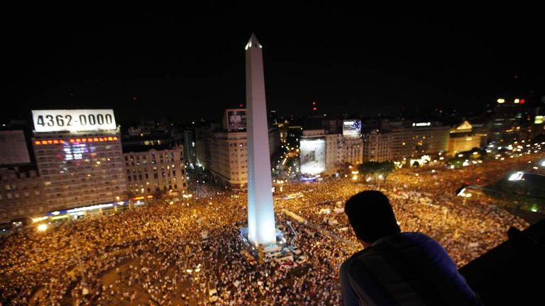 A man watches as protesters demonstrate during a march against Argentina's President Cristina Fernandez