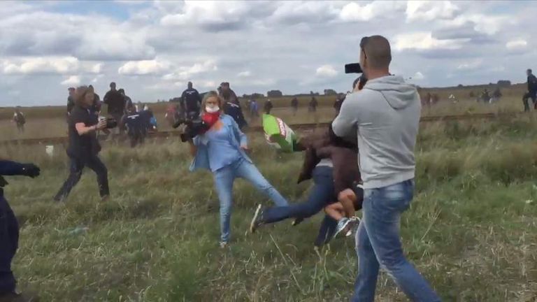 Hungarian camerawoman appears to trip up fleeing refugee with child