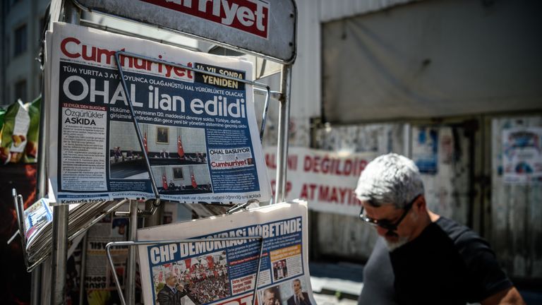 A man reads the newspaper front pages after the failed coup