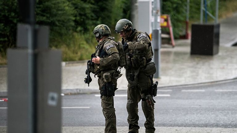 Heavily armed police officers with weapons prepare to respond to a shooting