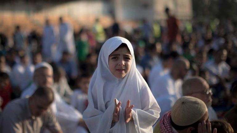 A Palestinian girl takes part in the morning Eid al-Fitr prayer in Gaza City