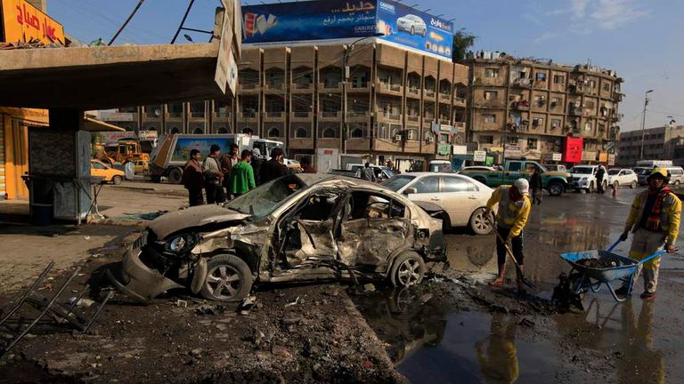 People gather at the site of car bomb attack in Baghdad
